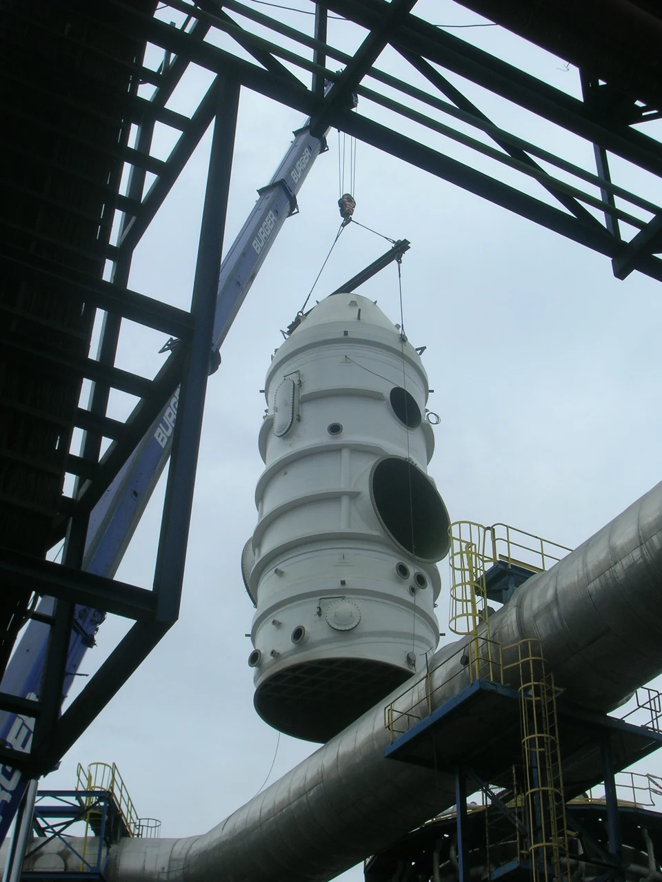 Equipo industrial siendo instalado mediante una grúa en una planta.