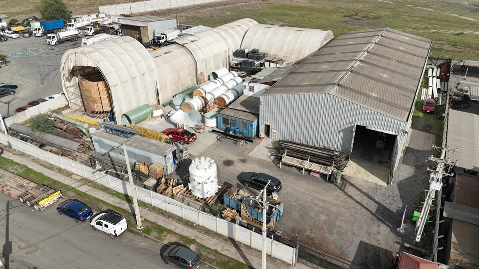 Vista aérea de la planta, con las carpas de fabricación, la nave metálica y equipos y ductos dispuestos en el patio.