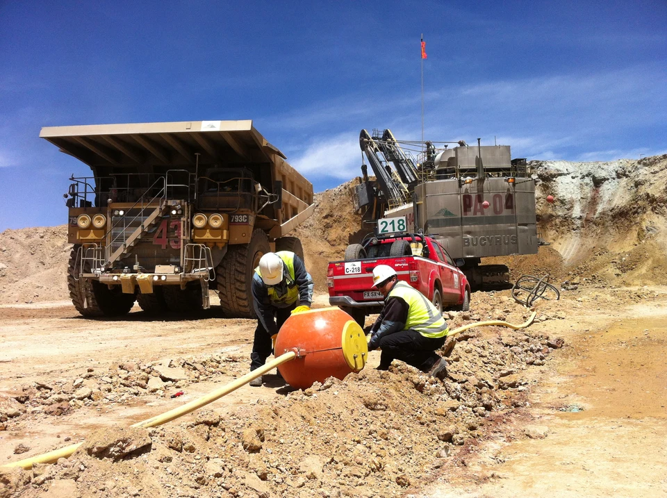 Trabajadores realizando labores en terreno en una operación industrial.